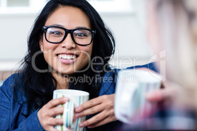 Portrait of young woman having coffee with friend