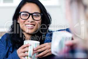 Portrait of young woman having coffee with friend