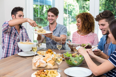 Friends having meal at table in house