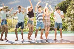 Group of friends dancing at poolside