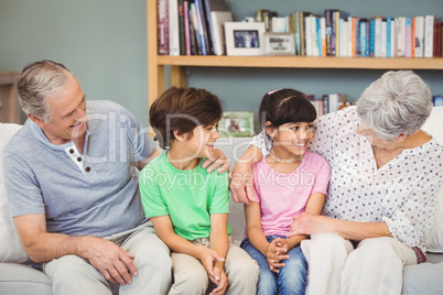 Grandchildren with grandparents on sofa