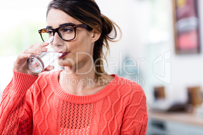 Beautiful young woman drinking water in glass