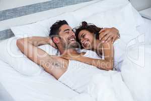 Happy couple relaxing on bed