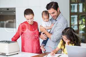 Smiling family with daughter studying at desk