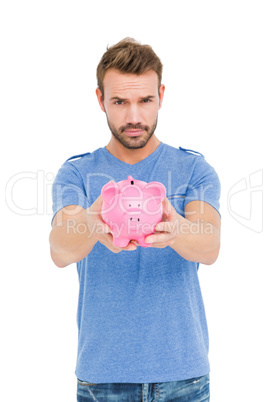 Young man holding a piggy bank