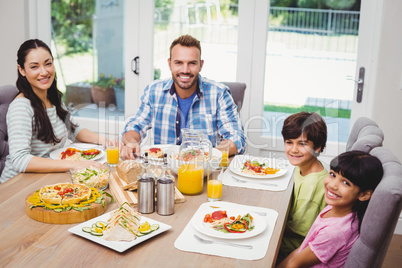 Portrait of smiling family sitting at dining table