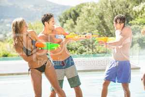 Happy friends doing water gun battle
