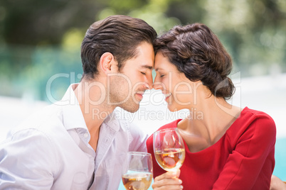 Romantic couple with eyes closed while holding white wine