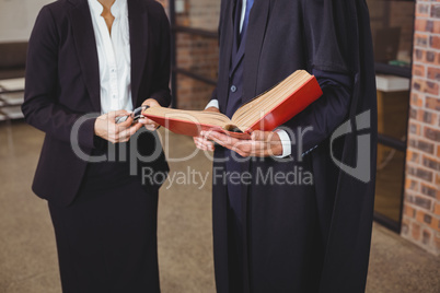 Male lawyer with female colleague discussing over book