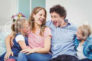 Cheerful couple with children at home