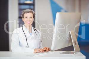 Portrait of smiling doctor working at computer desk