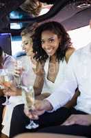 Well dressed woman drinking champagne in a limousine