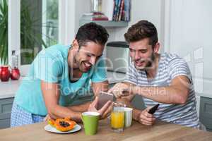 Happy male friends using phone