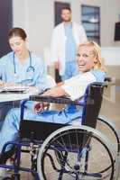 Portrait of cheerful female doctor sitting on wheelchair