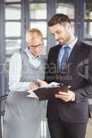 Business people discussing over documents in office