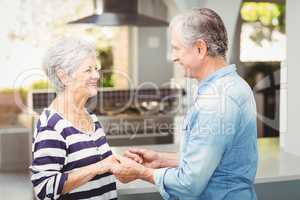 Side view of happy senior couple holding hands