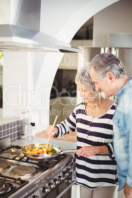 Senior couple cooking food in kitchen