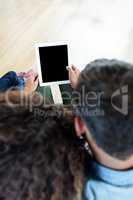 Couple using a digital tablet on sofa