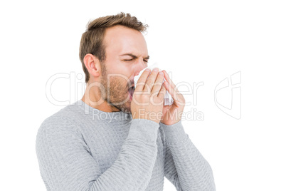 Young man holding a tissue and sneezing