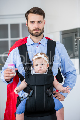 Man in superhero costume carrying daughter