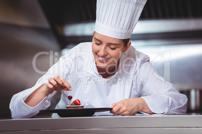 Chef putting a cherry on a dessert