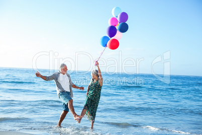 Senior couple holding balloons