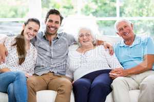 Portrait of smiling multi-generation family sitting on sofa