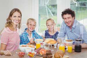 Happy family having breakfast at table