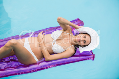 Smiling young woman relaxing on inflatable raft