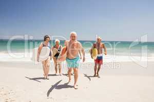 Senior friends holding surfboard