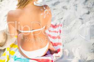 Woman sitting on a towel at the beach