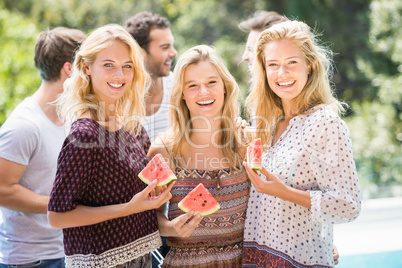 Young women smiling and having a slice of water melon