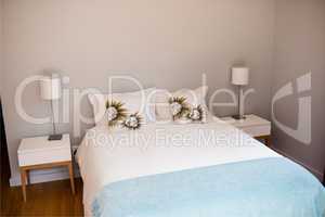 Empty bed with white bed sheet