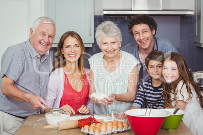 Portrait of happy family cooking food in kitchen