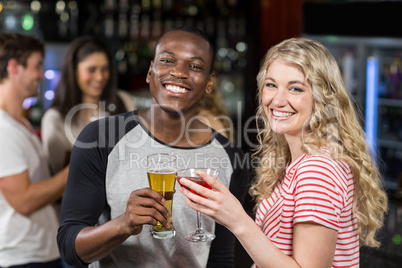 Friends toasting with cocktail and beer