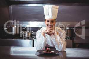 Chef leaning on the counter with a dish