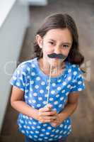 Portrait of girl with artificial mustache