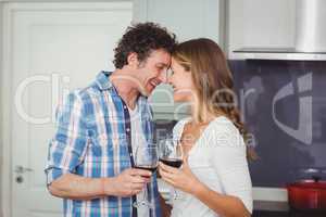 Young couple standing face to face in kitchen