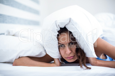 Irritated woman lying on bed
