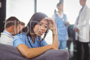 Tensed doctor sitting on sofa