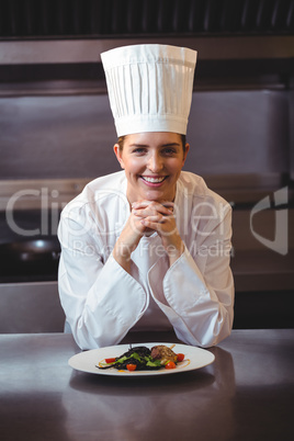 Chef leaning on the counter with a dish