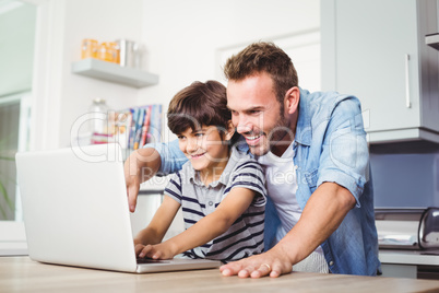 Father and son using laptop