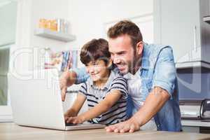 Father and son using laptop