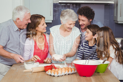 Smiling grandmother cooking food with family