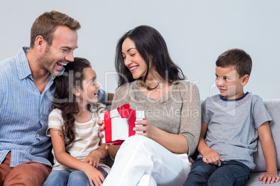 Children giving a surprise gift to their mother