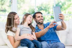 Happy family clicking selfie with digital tablet