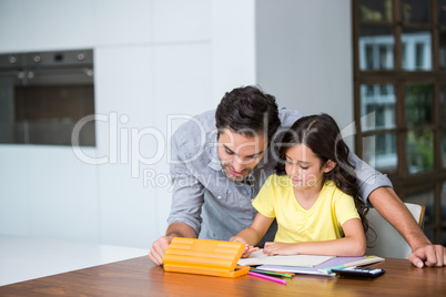 Father assisting daughter with homework