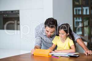 Father assisting daughter with homework