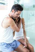 Man consoling wife while looking at pregnancy kit