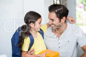 Smiling father and daughter with lunch box